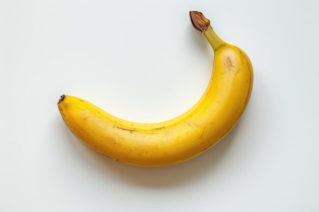 Foto uma banana amarela isolada em fundo branco uma banana amarela senta-se em cima de uma mesa branca criando