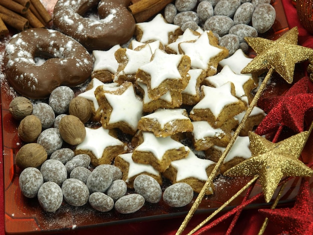 Foto uma bandeja de biscoitos e uma varinha com uma fita vermelha e uma estrela dourada.