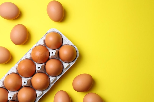 Foto uma bandeja de ovos em um fundo amarelo