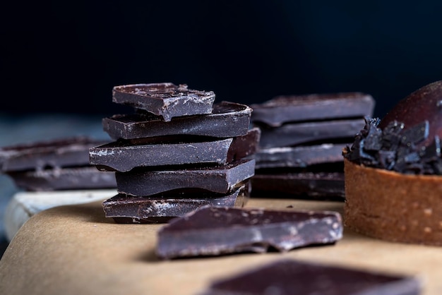 Uma barra de chocolate ao leite quebrada em um grande número de pedaços pedaços de chocolate ao leite estão sobre a mesa