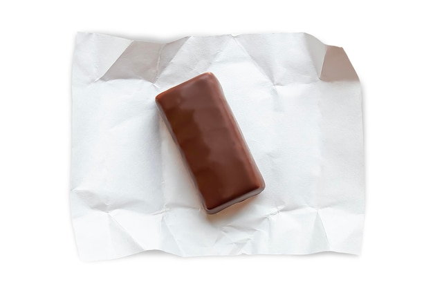 Uma barra de chocolate está em um invólucro de papel branco isolado em fundo branco
