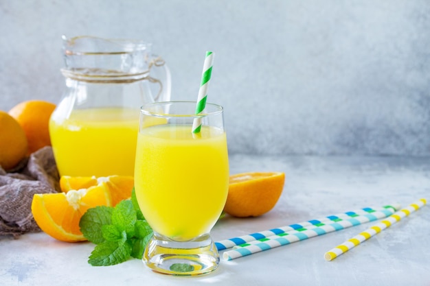 Uma bebida refrescante de verão com suco de laranja, laranjas frescas e hortelã Copiar espaço