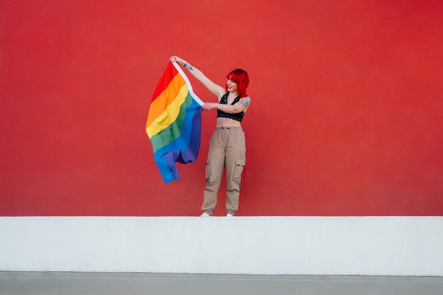 Uma bela foto de uma fêmea agitando uma bandeira colorida com um fundo vermelho