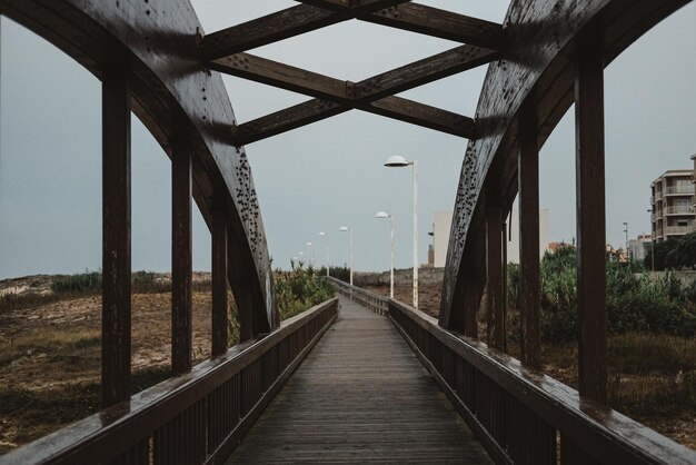 Uma bela foto de uma ponte de madeira arqueada única em um dia chuvoso