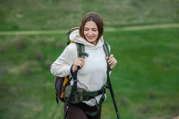 Uma bela garota europeia está caminhando nas montanhas. Uma mulher branca viaja com mochila na natureza.