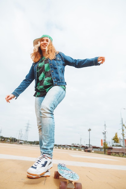 Uma bela jovem adolescente anda de skate na geração z de clima ensolarado