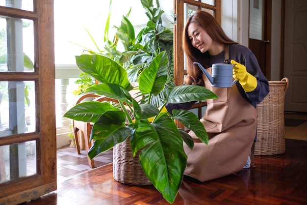 Uma bela jovem asiática cuidando e regando as plantas de casa regando a lata em casa