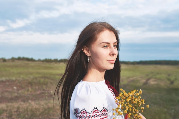 Foto uma bela jovem de pé no campo contra o céu