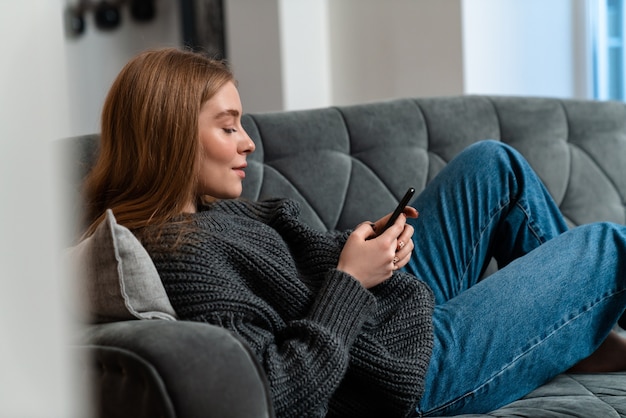 Uma bela jovem dentro de casa em casa usando telefone celular.