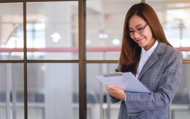 Uma bela jovem empresária asiática trabalhando em papelada de negócios no escritório