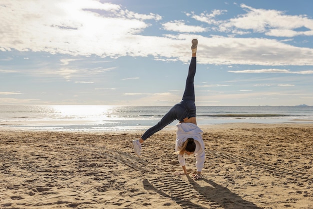 Uma bela jovem enérgica fazendo ginástica na praia