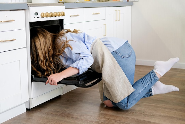 Uma bela jovem enfia a cabeça no forno e verifica se a torta está pronta. Humor