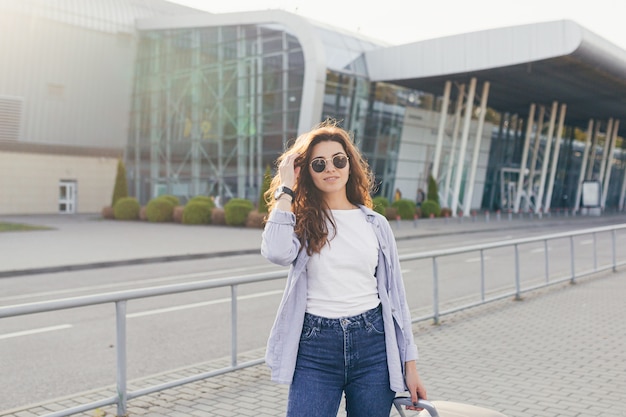 Uma bela jovem estudante sai do aeroporto em uma nova cidade e espera por um táxi