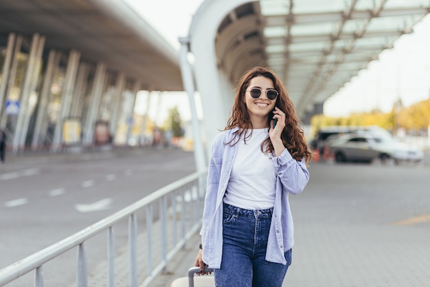 Uma bela jovem estudante sai do aeroporto em uma nova cidade e espera por um táxi