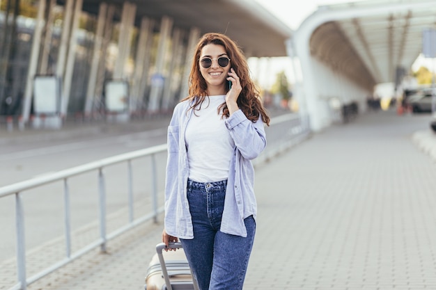 Uma bela jovem estudante sai do aeroporto em uma nova cidade e espera por um táxi