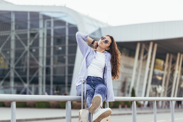 Uma bela jovem estudante sai do aeroporto em uma nova cidade e espera por um táxi