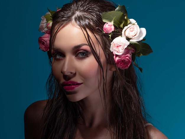 Uma bela jovem morena com olhos azuis brilhantes em uma imagem havaiana cabelo molhado e flores no hai...