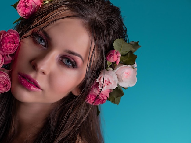 Uma bela jovem morena com olhos azuis brilhantes em uma imagem havaiana cabelo molhado e flores no hai...