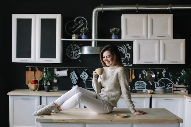 Foto uma bela jovem no interior da cozinha moderna