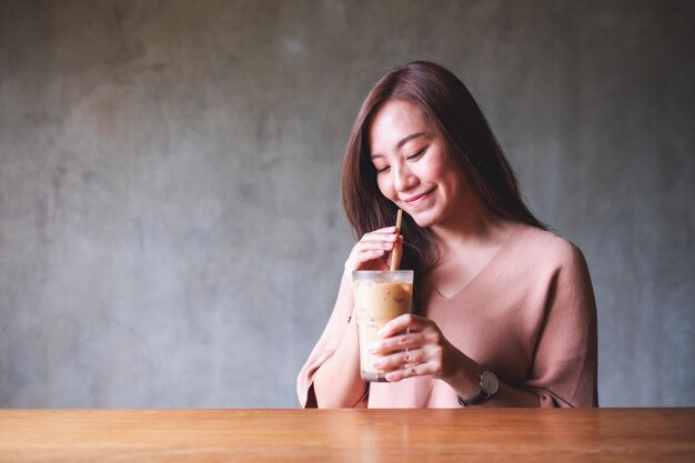 Uma bela jovem segurando e bebendo café gelado