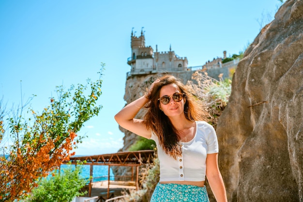 Uma bela jovem vai ao topo do castelo Swallows Nest na Crimeia