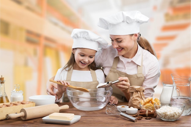 Uma bela mãe jovem e uma criança a cozinhar.