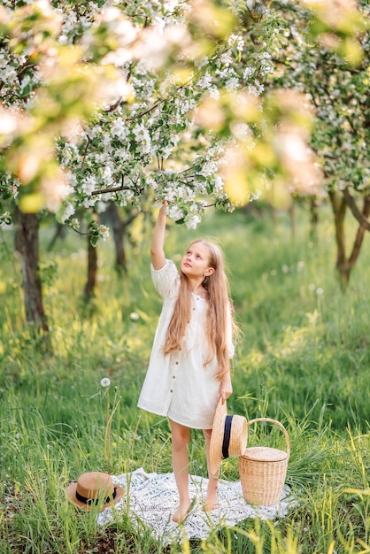 Foto uma bela menina perto de uma maçã em flor uma criança de vestido branco no jardim da primavera