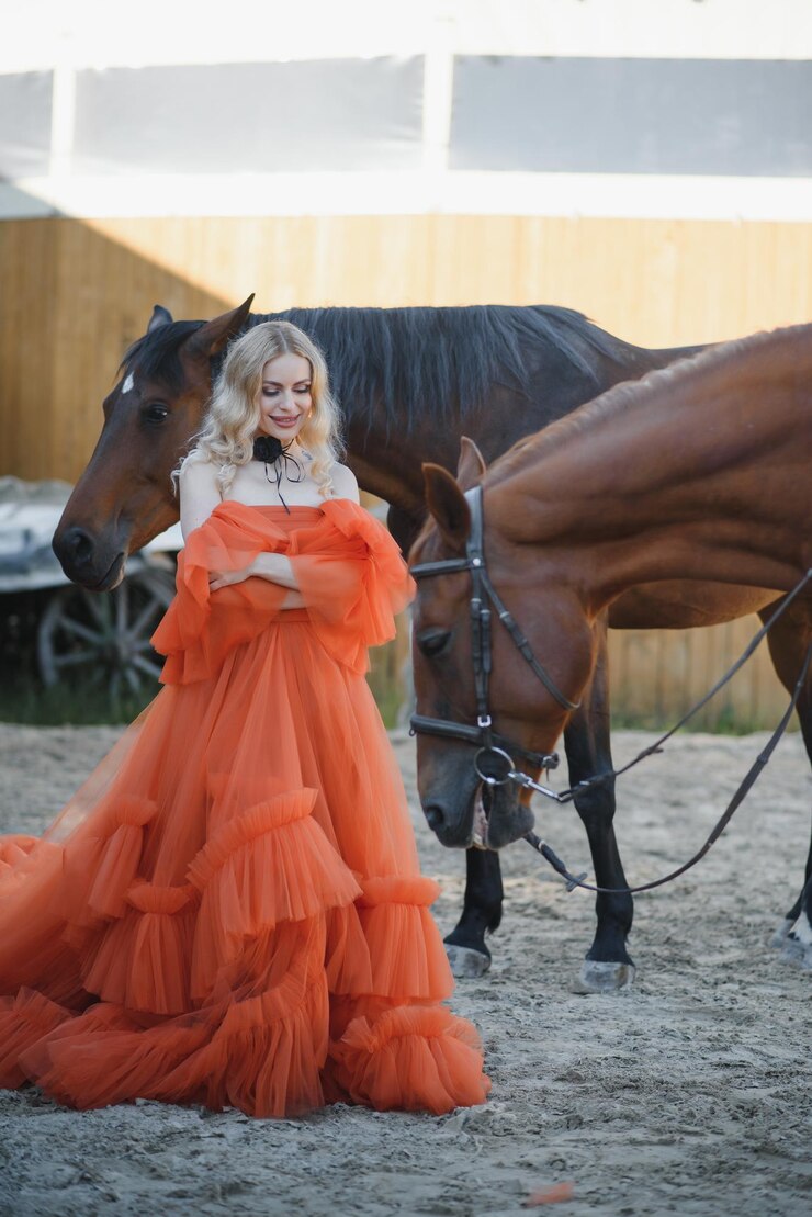 Foto uma bela modelo está de pé em um vestido longo com um cavalo