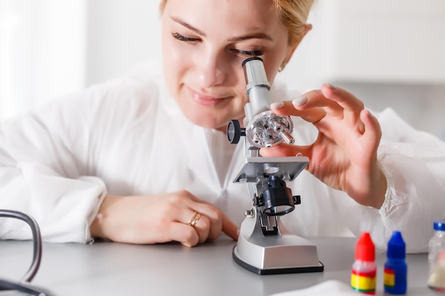 Uma bela pesquisadora médica ou científica usando seu microscópio em um laboratório.