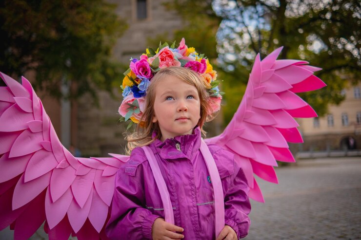 Foto uma bela rapariga com asas de anjo cor-de-rosa, uma rapariga bonita com um casaco rosa e asas rosas feitas à mão.