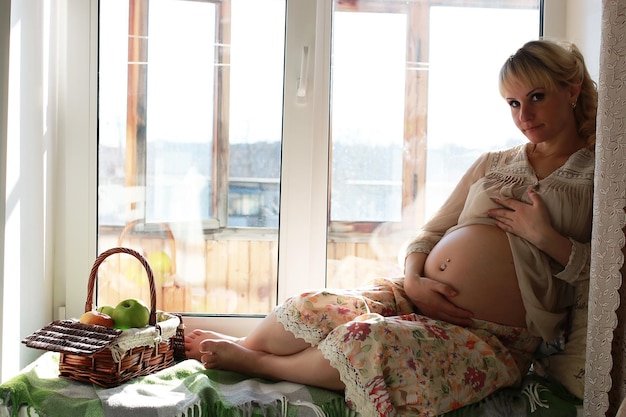 Uma bela rapariga loira grávida prepara-se para se tornar mãe