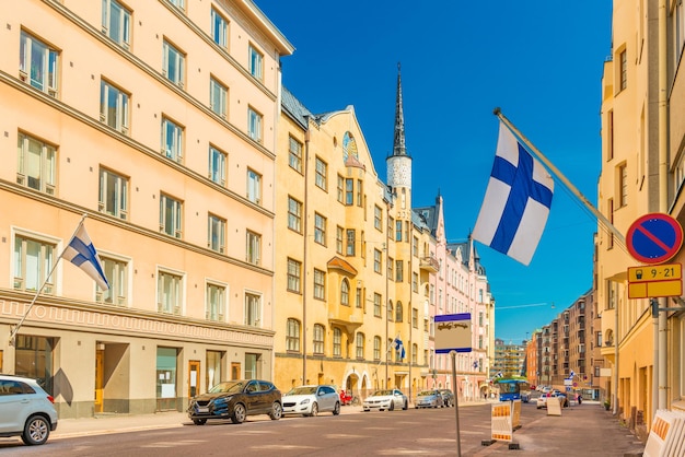 Uma bela rua em Helsinque com edifícios históricos coloridos com bandeiras finlandesas nas fachadas, Finlândia