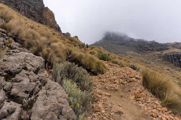 Uma bela vista da trilha rochosa até o vulcão Iztaccihuatl em meio à névoa