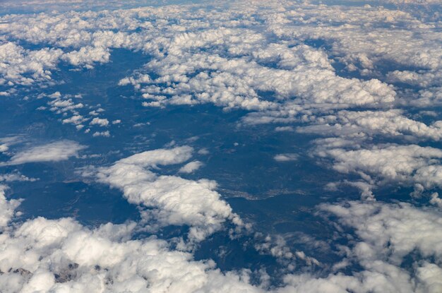 Uma bela vista das nuvens brancas penduradas acima do solo através do close da vista lateral da janela de vigia