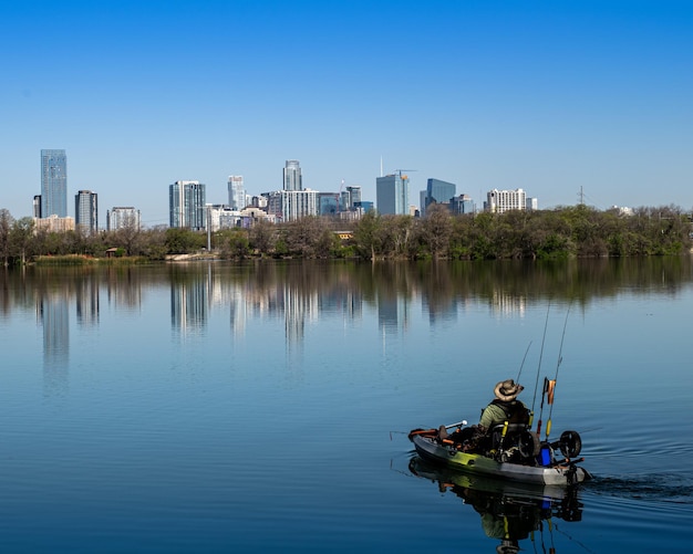Uma bela vista de um homem com um caiaque pescando em um lago perto do centro de Austin, Texas