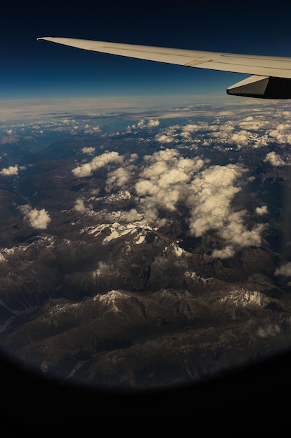 Foto uma bela vista de uma asa de avião e montanhas com nuvens