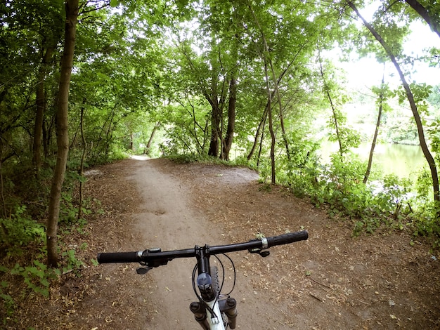Foto uma bicicleta fica em um caminho de terra na floresta. o conceito de turismo, recreação. copie o espaço.