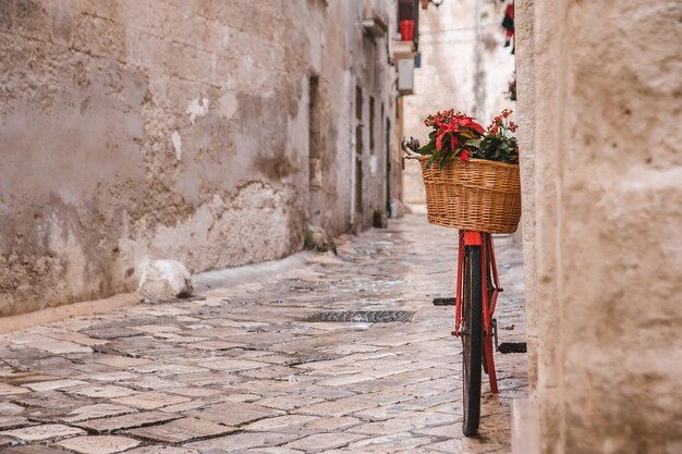 Foto uma bicicleta vermelha com uma cesta de flores em uma rua