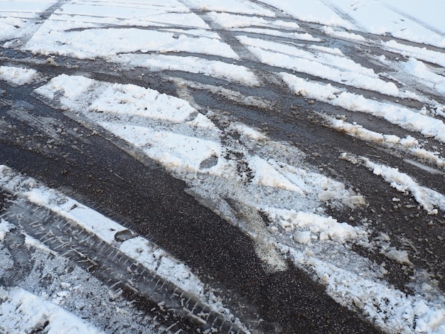 Uma bifurcação ou desvio de uma rotunda Deslizamentos de neve na berma da estrada Mau tempo Neve no asfalto Condições de condução e tráfego difíceis Neve de neve na estrada Distância de travagem de um carro