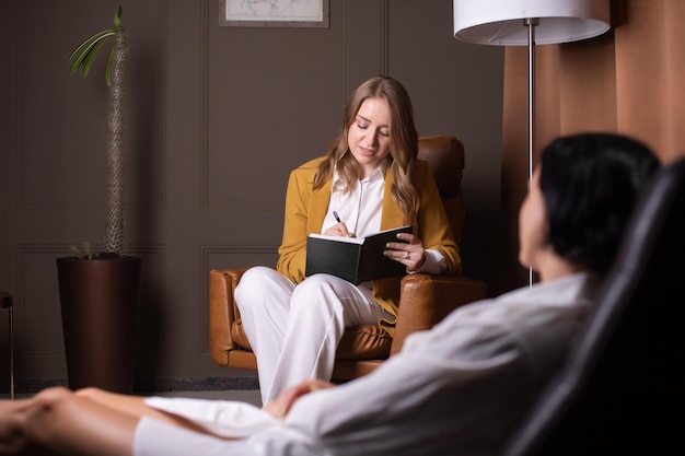 Uma boa mulher faz anotações sobre a saúde psicológica de um cliente