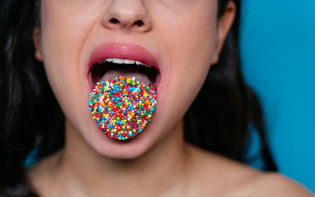 Uma boca feminina artística com salpicos coloridos na língua