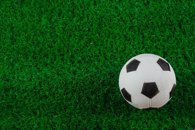 Uma bola de futebol fica na grama verde