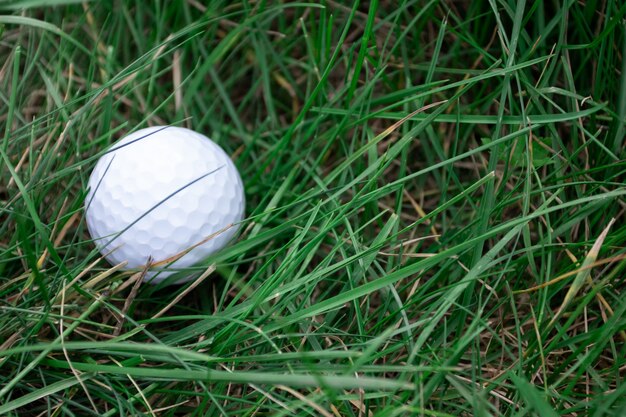 Uma bola de golfe branca na grama verde para jogar golfe