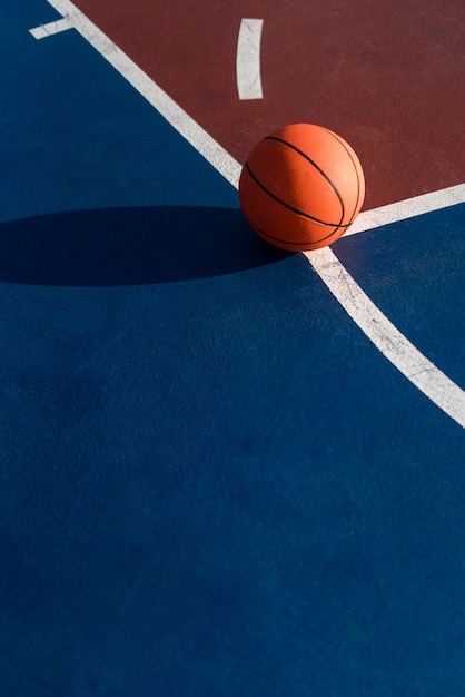 Uma bola laranja na quadra de basquete