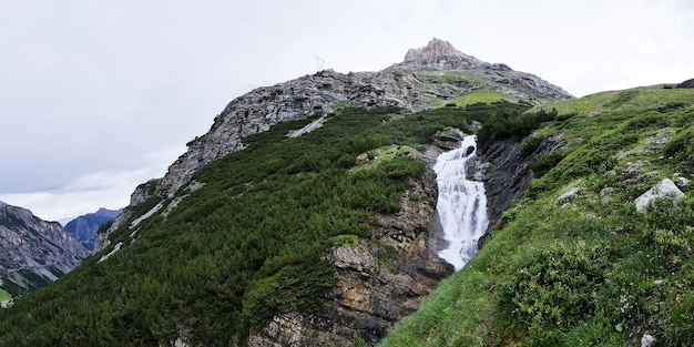 Uma cachoeira em uma montanha com uma cruz no topo