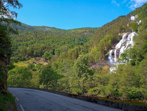 Foto uma cachoeira gigante na encosta de uma montanha arborizada soknefossen galdanefossen