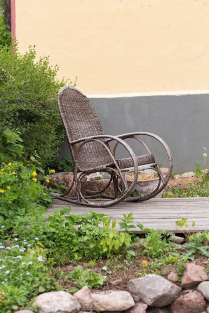 Foto uma cadeira de balanço velha vazia está no pátio da casa