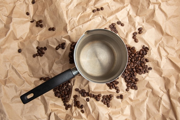 Uma cafeteira vazia cheia de grãos de café no fundo de papel kraft