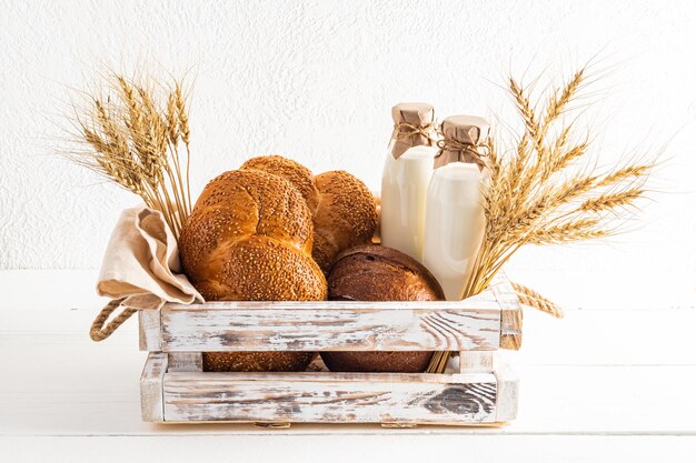 Uma caixa branca de madeira cheia de produtos tradicionais para a vista frontal do fundo branco do feriado de Shavuot