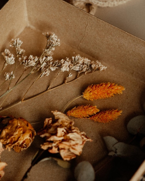 Uma caixa de flores secas com uma flor amarela.